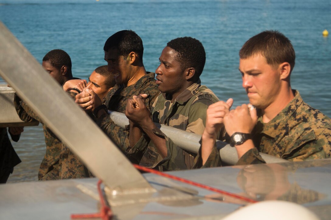 NOUMEA, NEW CALEDONIA— Marines with 3rd Battalion, 4th Marine Regiment, currently deployed to Koa Moana 17, and French army soldiers relocate a piece of an obstacle course after participating in the French Nautical Commando Course during exercise Koa Moana 17, July 3, 2017, in Noumea, New Caledonia. Koa Moana 17 is designed to improve theater security, and conduct law enforcement and infantry training in the Pacific region in order to enhance interoperability with partner nations. (U.S. Marine Corps Photo by Sgt. Douglas D. Simons)