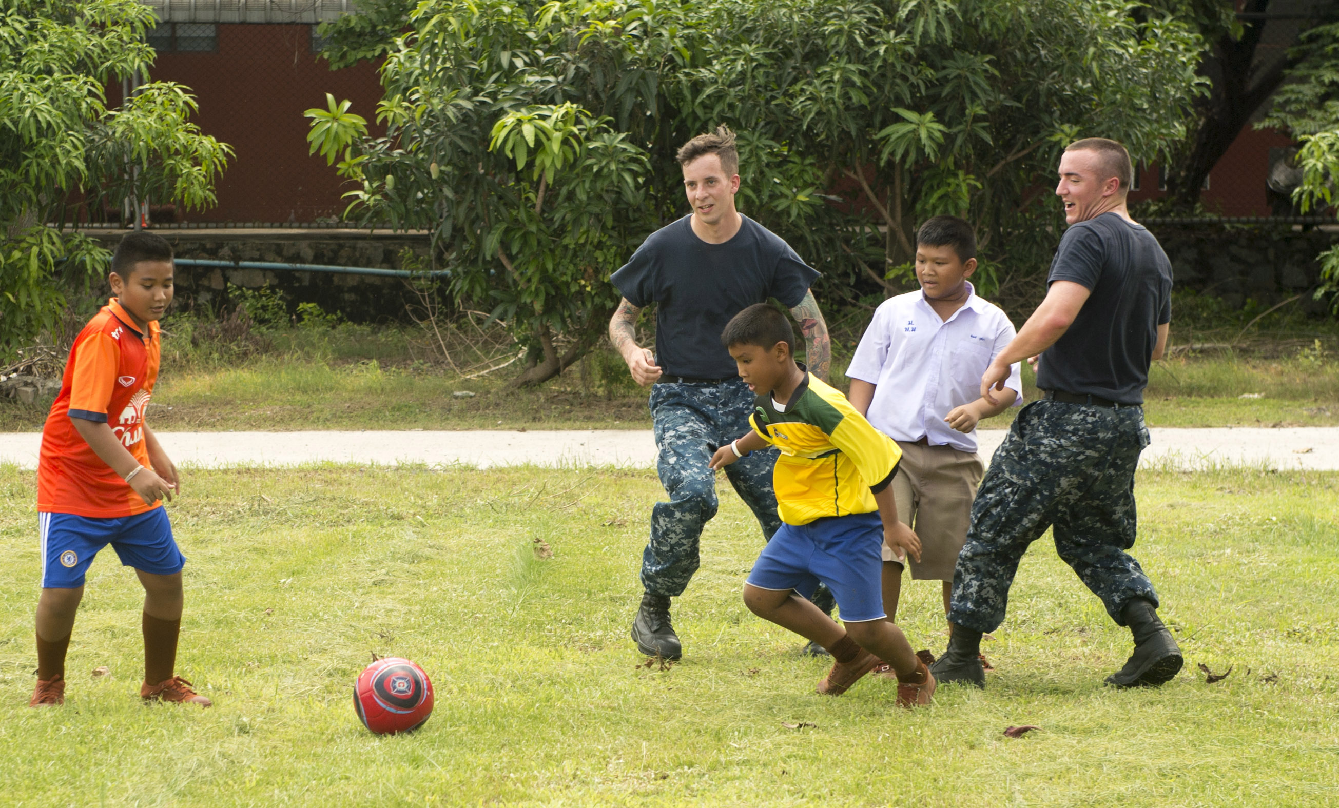 170530-N-PD309-077 PATTAYA, Thailand (May 30, 2017) Sailors assigned to littoral combat ship USS Coronado (LCS 4) play soccer with children at Ban Bang Lamung School as part of a community relations event during Cooperation Afloat Readiness and Training (CARAT) Thailand. CARAT is a series of Pacific Command-sponsored, U.S Pacific Fleet-led bilateral exercises held annually in South and Southeast Asia to strengthen relationships and enhance force readiness. CARAT exercise events cover a broad range of naval skill areas and disciplines including surface, undersea, air, and amphibious warfare; maritime security operations; riverine, jungle, and explosive ordnance disposal operations; combat construction; diving and salvage; search and rescue; maritime patrol and reconnaissance aviation; maritime domain awareness; military law, public affairs and military medicine; and humanitarian assistance and disaster response. (U.S. Navy photo by Mass Communication Specialist 3rd Class Deven Leigh Ellis/Released)