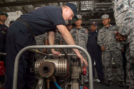 170530-N-PD309-074 SATTAHIP NAVAL BASE, Thailand (May 31, 2017) Hull Technician 1st Class Joshua Lepus conducts damage control training on a P-100 pump for Royal Thai Navy sailors aboard littoral combat ship USS Coronado (LCS 4) during Cooperation Afloat Readiness and Training (CARAT) Thailand. CARAT is a series of Pacific Command-sponsored, U.S Pacific Fleet-led bilateral exercises held annually in South and Southeast Asia to strengthen relationships and enhance force readiness. CARAT exercise events cover a broad range of naval skill areas and disciplines including surface, undersea, air, and amphibious warfare; maritime security operations; riverine, jungle, and explosive ordnance disposal operations; combat construction; diving and salvage; search and rescue; maritime patrol and reconnaissance aviation; maritime domain awareness; military law, public affairs and military medicine; and humanitarian assistance and disaster response. (U.S. Navy photo by Mass Communication Specialist 3rd Class Deven Leigh Ellis/Released)