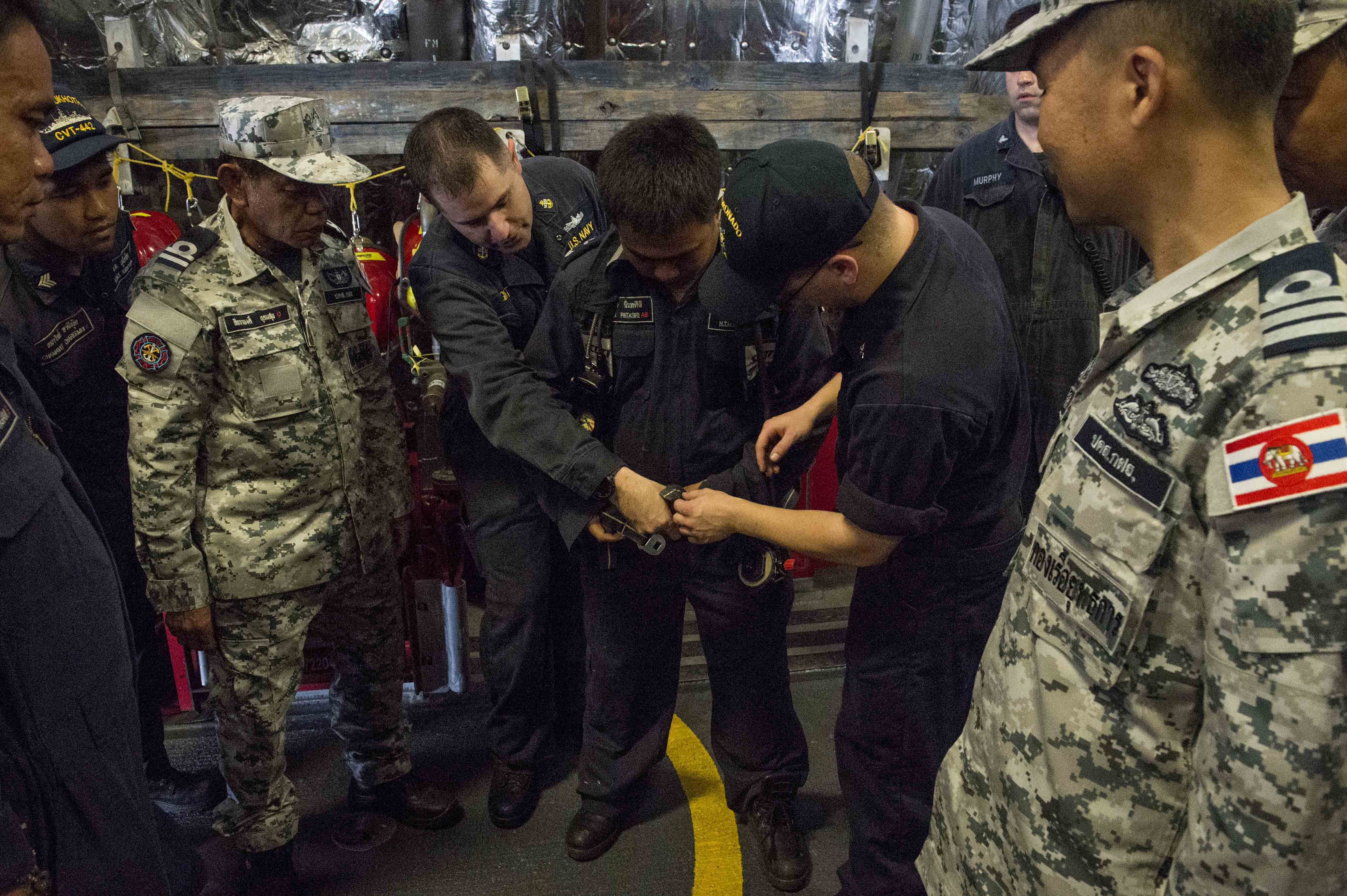 170530-N-PD309-100 SATTAHIP NAVAL BASE, Thailand (May 31, 2017) Sailors aboard littoral combat ship USS Coronado (LCS 4) assist a Royal Thai Navy sailor donning a Self-contained Breathing Apparatus (SCBA) during a damage control training session in support of Cooperation Afloat Readiness and Training (CARAT) Thailand. CARAT is a series of Pacific Command-sponsored, U.S Pacific Fleet-led bilateral exercises held annually in South and Southeast Asia to strengthen relationships and enhance force readiness. CARAT exercise events cover a broad range of naval skill areas and disciplines including surface, undersea, air, and amphibious warfare; maritime security operations; riverine, jungle, and explosive ordnance disposal operations; combat construction; diving and salvage; search and rescue; maritime patrol and reconnaissance aviation; maritime domain awareness; military law, public affairs and military medicine; and humanitarian assistance and disaster response. (U.S. Navy photo by Mass Communication Specialist 3rd Class Deven Leigh Ellis/Released)