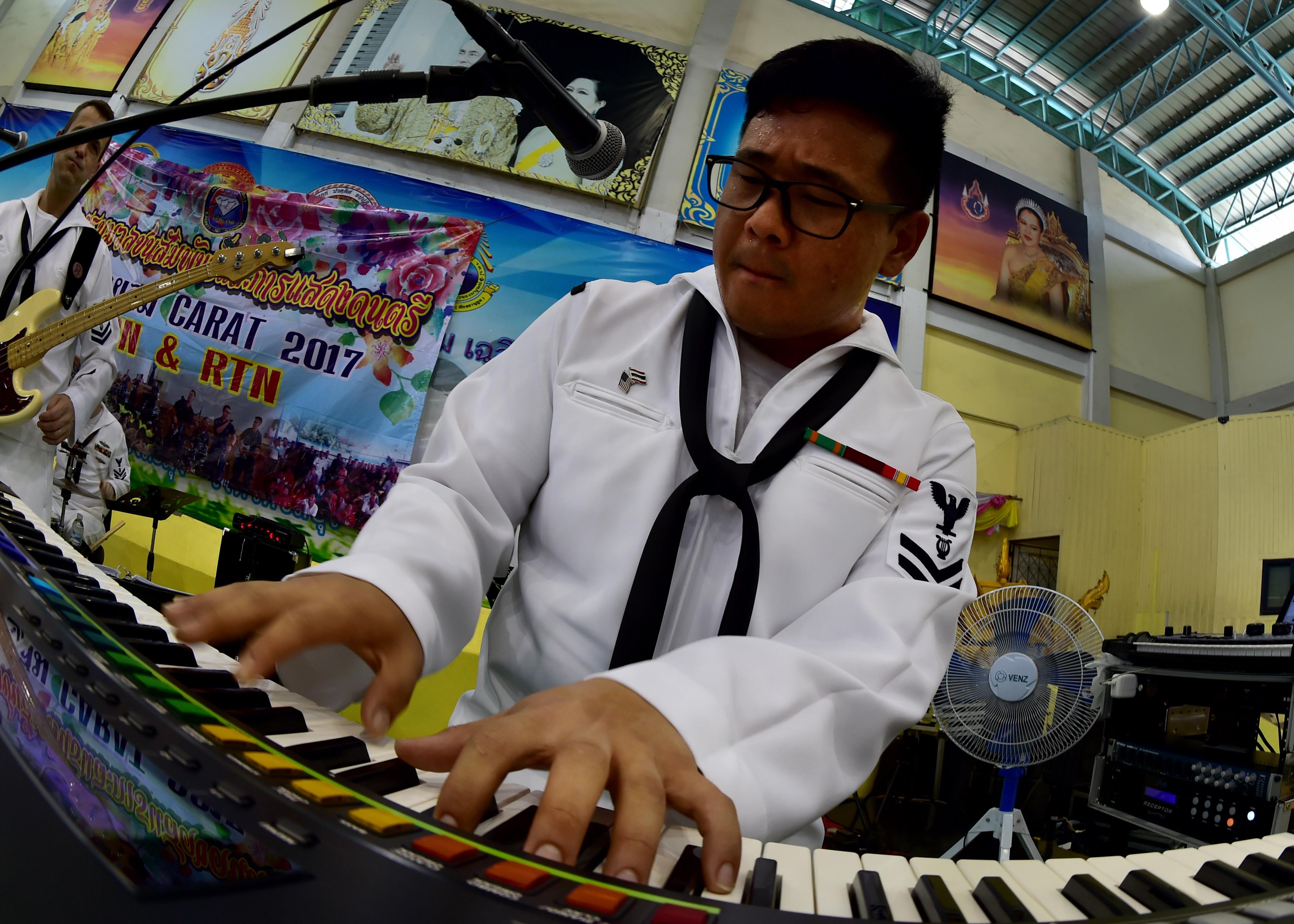 170602-N-QV906-069 PATTAYA, Thailand (June 2, 2017) Navy Musician 2nd Class Daniel Park, of the U.S. 7th Fleet Band, Orient Express, jams
out during a performance at Pattaya City No. 8 School as part of Cooperation Afloat Readiness and Training Thailand 2017 in Pattaya,
Thailand, June 2. Cooperation Afloat Readiness and Training (CARAT) is a series of PACOM sponsored, U.S. Pacific Fleet led bilateral
exercises held annually in South and Southeast Asia to strengthen relationships and enhance force readiness. CARAT exercise events cover
a broad range of naval skill areas and disciplines including surface, undersea, air and amphibious warfare; maritime security operations;
riverine, jungle and explosive ordnance disposal operations; combat construction; diving and salvage; search and rescue; maritime patrol
and reconnaissance aviation; maritime domain awareness; military law, public affairs and military medicine; and humanitarian assistance,
disaster response. (U.S. Navy photo by Mass Communication Specialist 1st Class Micah Blechner/RELEASED)