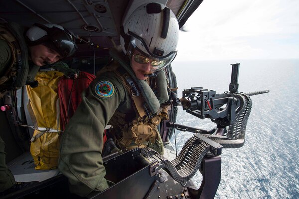 170603-N-PD309-1142 GULF OF THAILAND, Thailand (June 3, 2017) Naval Aircrewman (Helicopter) 2nd Class Nicholas Lovelace, right, assigned to the "Wildcards" of Helicopter Sea Combat Squadron 23 aboard littoral combat ship USS Coronado (LCS 4), loads rounds into a .50 caliber machine gun during a gunnery exercise with the Royal Thai Navy in support of Cooperation Afloat Readiness and Training (CARAT) Thailand. CARAT is a series of Pacific Command-sponsored, U.S Pacific Fleet-led bilateral exercises held annually in South and Southeast Asia to strengthen relationships and enhance force readiness. CARAT exercise events cover a broad range of naval skill areas and disciplines including surface, undersea, air, and amphibious warfare; maritime security operations; riverine, jungle, and explosive ordnance disposal operations; combat construction; diving and salvage; search and rescue; maritime patrol and reconnaissance aviation; maritime domain awareness; military law, public affairs and military medicine; and humanitarian assistance and disaster response. (U.S. Navy photo by Mass Communication Specialist 3rd Class Deven Leigh Ellis/Released)
