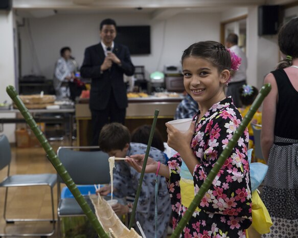 Celeste Hill, a Marine Corps Air Station Iwakuni resident, eats somen nagashi, or sliding somen noodles, during a visit to Kinjuen Nursing Home with the MCAS Iwakuni Cultural Adaptation Program in Iwakuni City, Japan, July 7, 2017. The nursing home invited tenants of the air station to celebrate Tanabata, also known as the star festival. Participants of the event enjoyed traditional foods and other activities. Nobuo Kishi, center, the vice minister of foreign affairs of Japan and younger brother of Prime Minister Shinzo Abe, joined the festivities with nursing home residents and Americans visiting from the air station. (U.S. Marine Corps photo by Lance Cpl. Gabriela Garcia-Herrera)