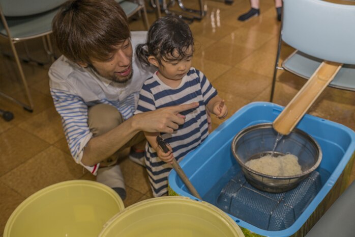 Go Fukuda, left, owner of Kinjuen Nursing Home, shows his daughter the bamboo ramp where noodles slide down during a nursing home visit with the Marine Corps Air Station Iwakuni Cultural Adaptation Program in Iwakuni City, Japan, July 7, 2017. The nursing home invited tenants of the air station to celebrate Tanabata, also known as the star festival. Participants of the event enjoyed somen nagashi, or sliding somen noodles, games and other activities. (U.S. Marine Corps photo by Lance Cpl. Gabriela Garcia-Herrera)