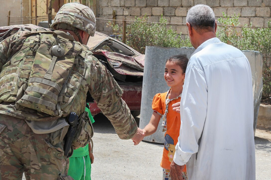 Army Col. Pat Work, commander, 82nd Airborne Division’s 2nd Brigade Combat Team, deployed in support of Combined Joint Task Force - Operation Inherent Resolve, greets a young resident of Mosul, Iraq, in a recently-liberated neighborhood, July 2, 2017. Army photo by Staff Sgt. Jason Hull