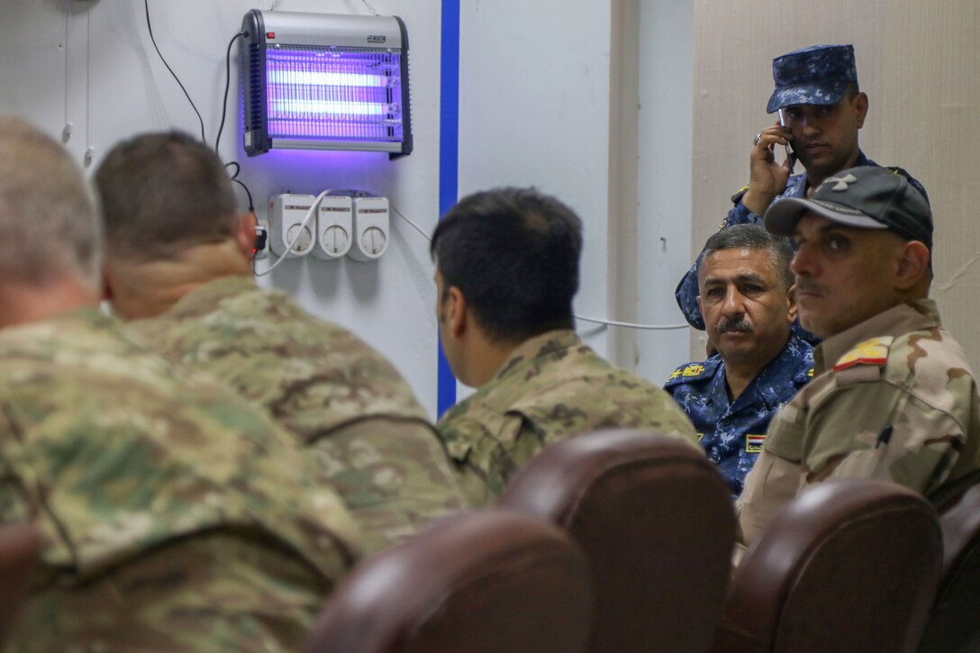 Coalition advisors and Iraqi security force members share information gained from a commercial unmanned aerial system feed searching for ISIS fighting positions from a tactical headquarters in Mosul, Iraq, July 3, 2017. Army photo by Staff Sgt. Jason Hull 