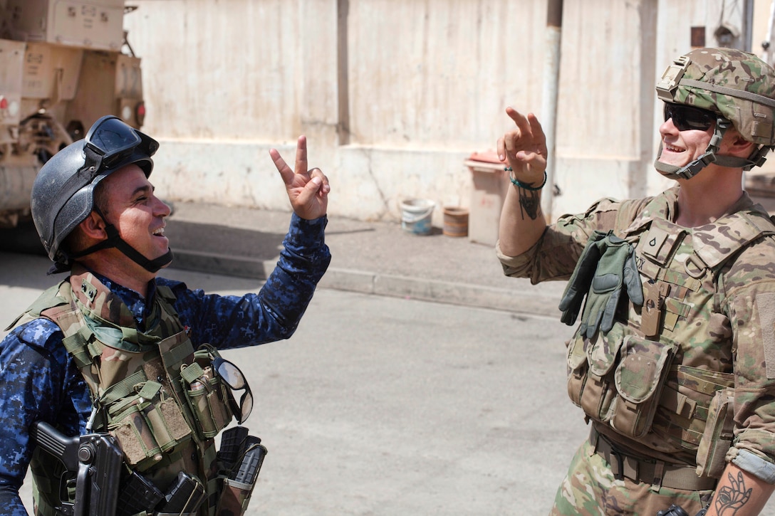 An Iraqi Federal Police officer and a U.S. Soldier give each other the peace sign while on patrol in Mosul, Iraq, July 4, 2017. The soldiers are paratroopers assigned to the 82nd Airborne Division’s 2nd Brigade Combat Team, Combined Joint Task Force - Operation Inherent Resolve. Army photo by Cpl. Rachel Diehm 