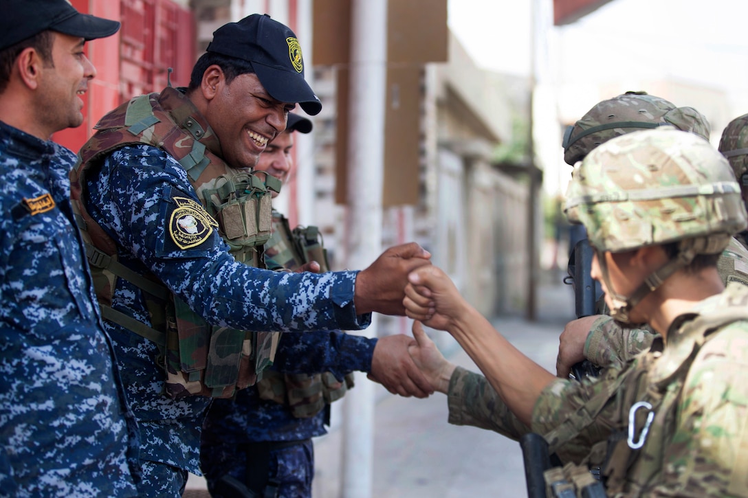 An Iraqi Federal Police officer fist bumps a U.S. paratroopers while on patrol in Mosul, Iraq, July 4, 2017. Army photo by Cpl. Rachel Diehm