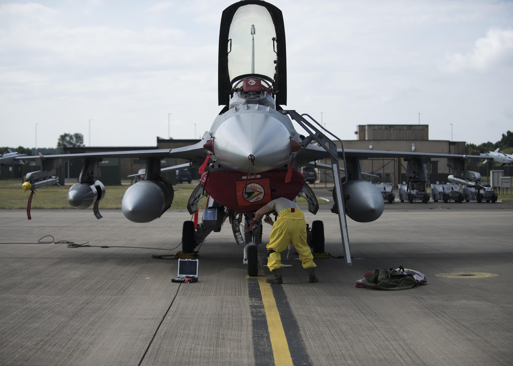 An Airman from the 52nd Fighter Wing at Spangdahlem Air Base, Germany, works on a parked F-16 Fighting Falcon assigned to the 52nd FW, at Royal Air Force Lakenheath, England, July 10. Airmen from the 52nd FW will train alongside 48th Fighter Wing Airmen and British Allies during a flying training deployment here, which is scheduled to last several weeks. (U.S. Air Force photo/Senior Airman Malcolm Mayfield)