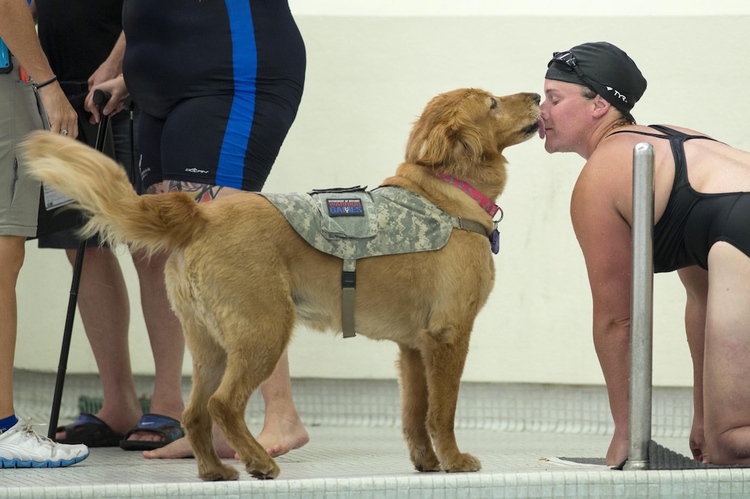Army veteran Sgt. Christina Gardner gets a kiss from Moxie, her military service dog, after competing in a swimming event during the 2017 Department of Defense Warrior Games in Chicago, July 8, 2017. DoD photo by Roger L. Wollenberg 