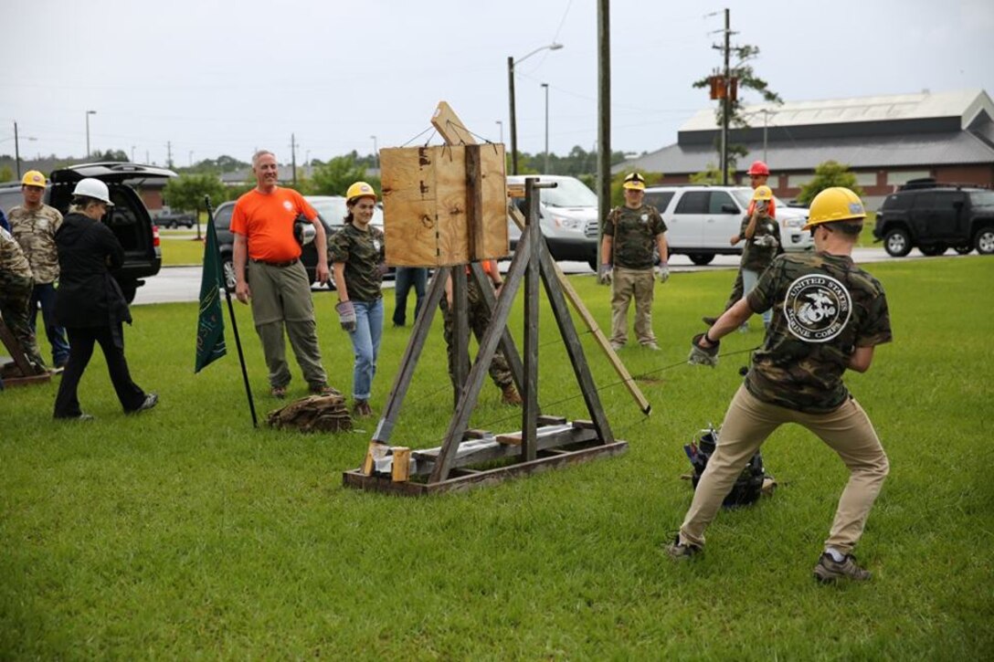 High school students from the Society of American Military Engineers (SAME) spent a day at the Construction Training Center (CTC), designing, and building trebuchets. Later in the day the students would have a friendly competition to see which trebuchet could launch a weight the farthest. Here a group students test their trebuchet and make any last minute adjustments before the competition. 