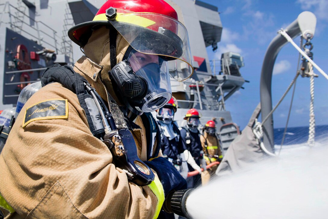 Navy Petty Officer 3rd Class Kevin Clark handles a fire hose during a general quarters training evolution aboard the Arleigh Burke-class guided-missile destroyer USS Pinckney in the Pacific Ocean, July 2, 2017. Clark is a damage controlman. Navy photo by Petty Officer 2nd Class Craig Z. Rodarte