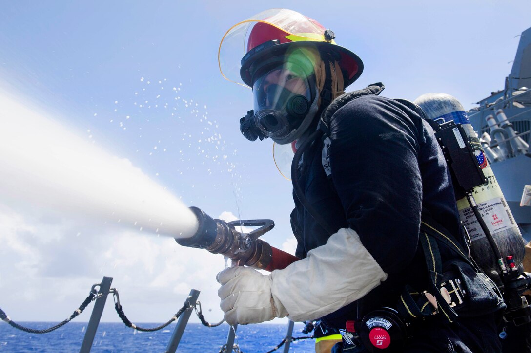 Navy Petty Officer 3rd Class Richard Bryant handles a fire hose during a general quarters training evolution aboard the Arleigh Burke-class guided-missile destroyer USS Pinckney in the Pacific Ocean, July 2, 2017. Navy photo by Petty Officer 2nd Class Craig Z. Rodarte