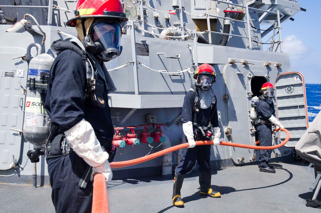Sailors prepare a fire hose before participating in firefighting training during a general quarters training evolution aboard the Arleigh Burke-class guided-missile destroyer USS Pinckney in the Pacific Ocean, July 2, 2017. Navy photo by Petty Officer 2nd Class Craig Z. Rodarte