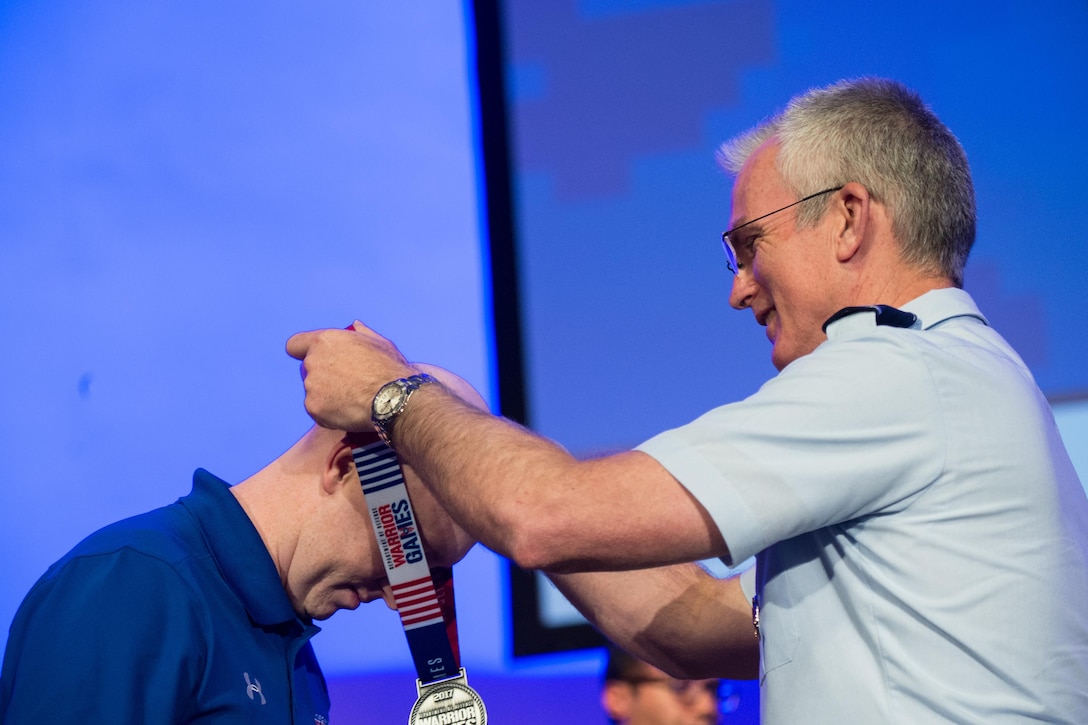 Air Force Gen. Paul J. Selva, vice chairman of the Joint Chiefs of Staff, presents Ret. Air Force Capt. Austin Williamson the Ultimate Champion Silver Medal during the closing ceremony for the 2017 Department of Defense Warrior Games in Chicago, July 8, 2017. DoD photo by Army Sgt. James K. McCann