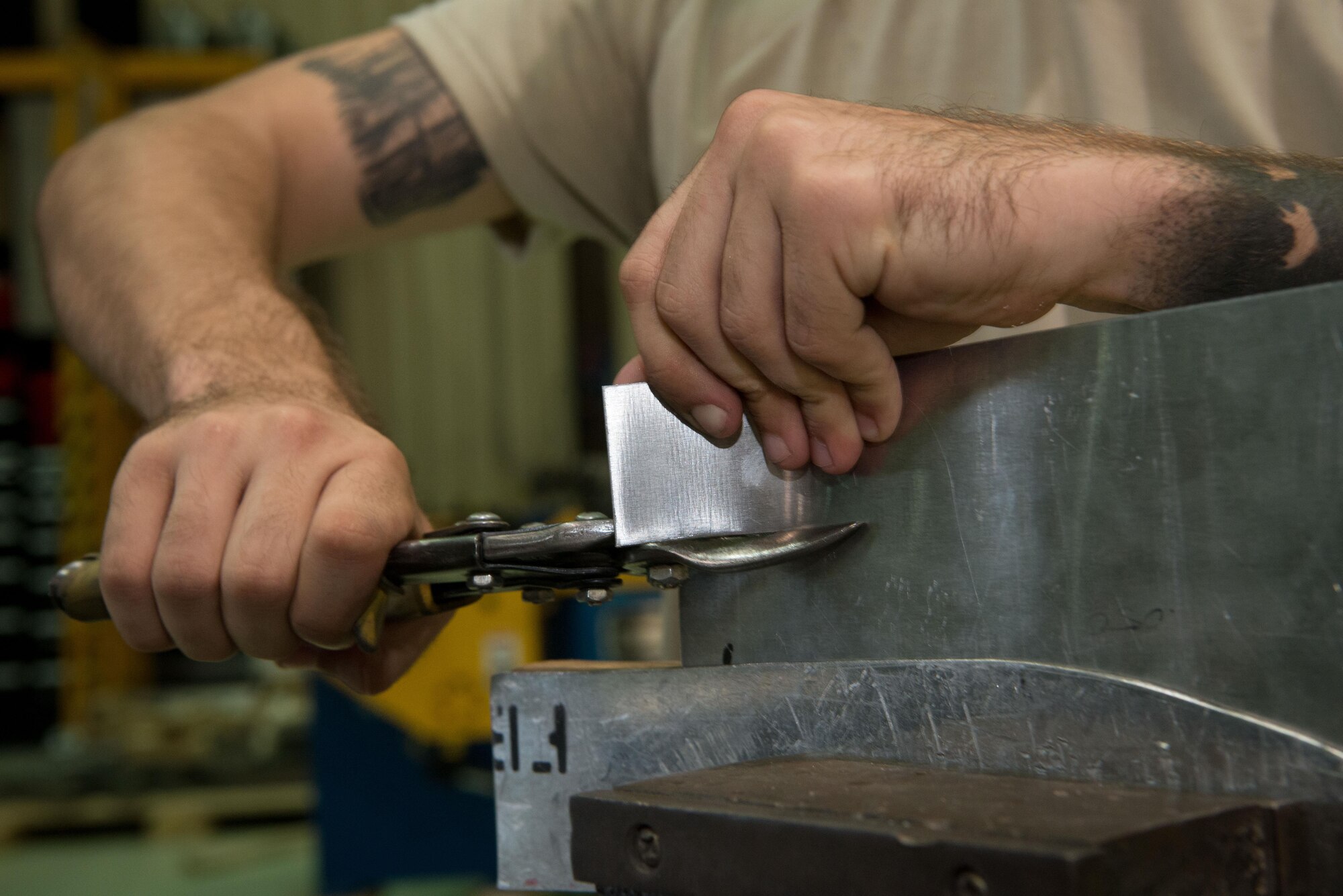 U.S. Air Force Airman 1st Class Luke Gibson, 86th Maintenance Squadron aircraft structural maintenance apprentice, uses aviation snips to pare down a piece of metal he is preparing to shape on Ramstein Air Base, Germany, July 5, 2017. When aircraft on Ramstein need new sheet metal parts, the aircraft structural maintenance shop uses a variety of cutting, crimping, and shaping tools to manufacture those parts in a timely and cost-efficient manner. (U.S. Air Force photo by Senior Airman Elizabeth Baker)