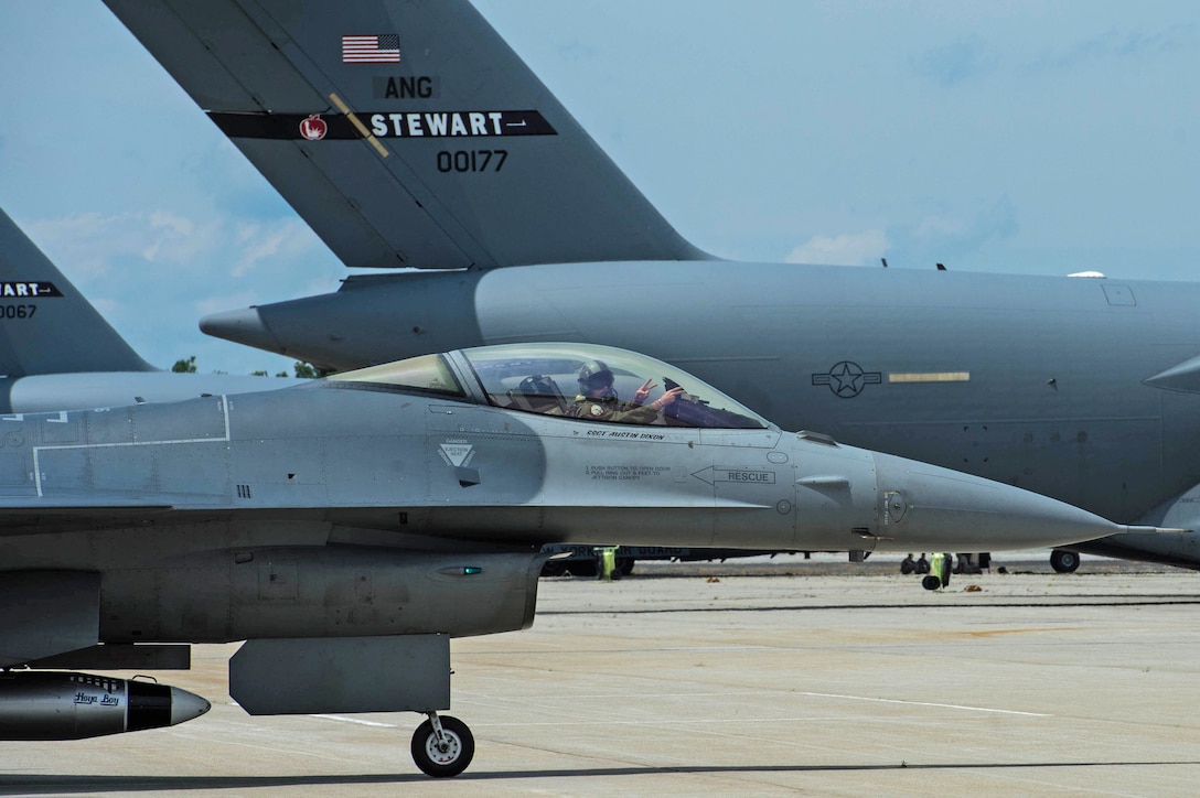 U.S. Air Force Maj. John Waters, F-16 Viper Demonstration Team pilot, makes the 77th Fighter Squadron (FS), “Gamblers,” hand sign as he taxis down a runway at Stewart International Airport, N.Y., June 29, 2017. Prior to being selected as the team pilot, Waters flew with the 77th FS and served as the 20th Fighter Wing’s chief of flight safety. (U.S. Air Force photo by Airman 1st Class Sean Sweeney)
