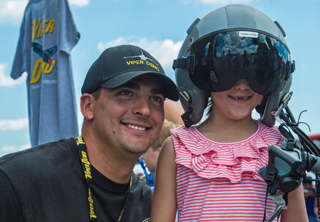 U.S. Air Force Tech. Sgt. Stephen Mullins, F-16 Viper demonstration team avionics specialist, smiles for a photo with a guest during the New York Air Show at Stewart International Airport, N.Y., July 2, 2017. The demo team performs at various air shows as a form of community outreach and recruitment for the Air Force. (U.S. Air Force photo by Airman 1st Class Sean Sweeney)