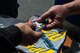 U.S. Air Force Tech. Sgt. Stephen Mullins, F-16 Viper Demonstration Team avionics specialist, hands out stickers to New York Air Show attendees at Stewart International Airport, N.Y., July 1, 2017. Members of the demo team interact with the public at air shows and answer questions about the F-16CM Fighting Falcon and Air Force to build public trust and support. (U.S. Air Force photo by Airman 1st Class Sean Sweeney)