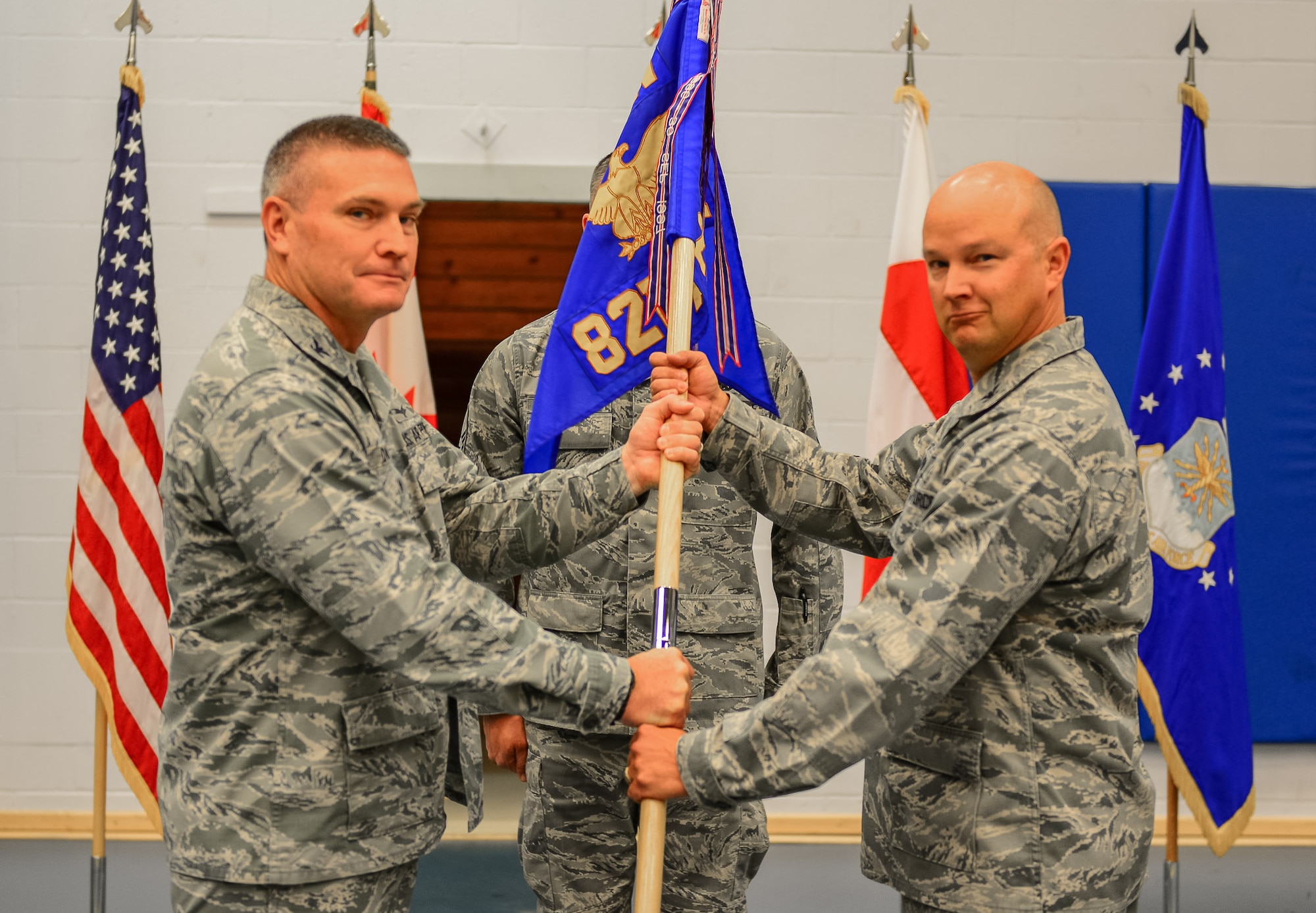 THULE AIR BASE, Greenland – Col. Eric Dorminey, 21st Space Wing vice commander, passes the guidon to Col. Thomas Colvin, 821st Air Base Group commander, during the 821st Air Base Group change of command ceremony, June 29, 2017, at Thule Air Base, Greenland. The group operates and maintains the air base in support of missile warning, space surveillance, satellite command and control operations missions. The group provides security, communications, civil engineering, personnel, services, logistics and medical support to remote active duty units in a combined U.S., Canadian, Danish and Greenlandic environment of approximately 550 military, civilian and contractor personnel. (U.S. Air Force photo by Capt. Md Hussain)