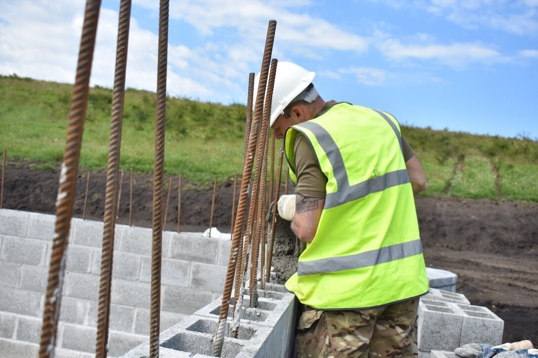 A Soldier of the U.K. Royal Monmouthshire Royal Engineers pours grout for a Light Demolition Range as part of Operation Resolute Castle 2017 at the Joint National Training Center, Cincu, Romania. Resolute Castle is an exercise strengthening the NATO alliance and enhancing its capacity for joint training and response to threats within the region.