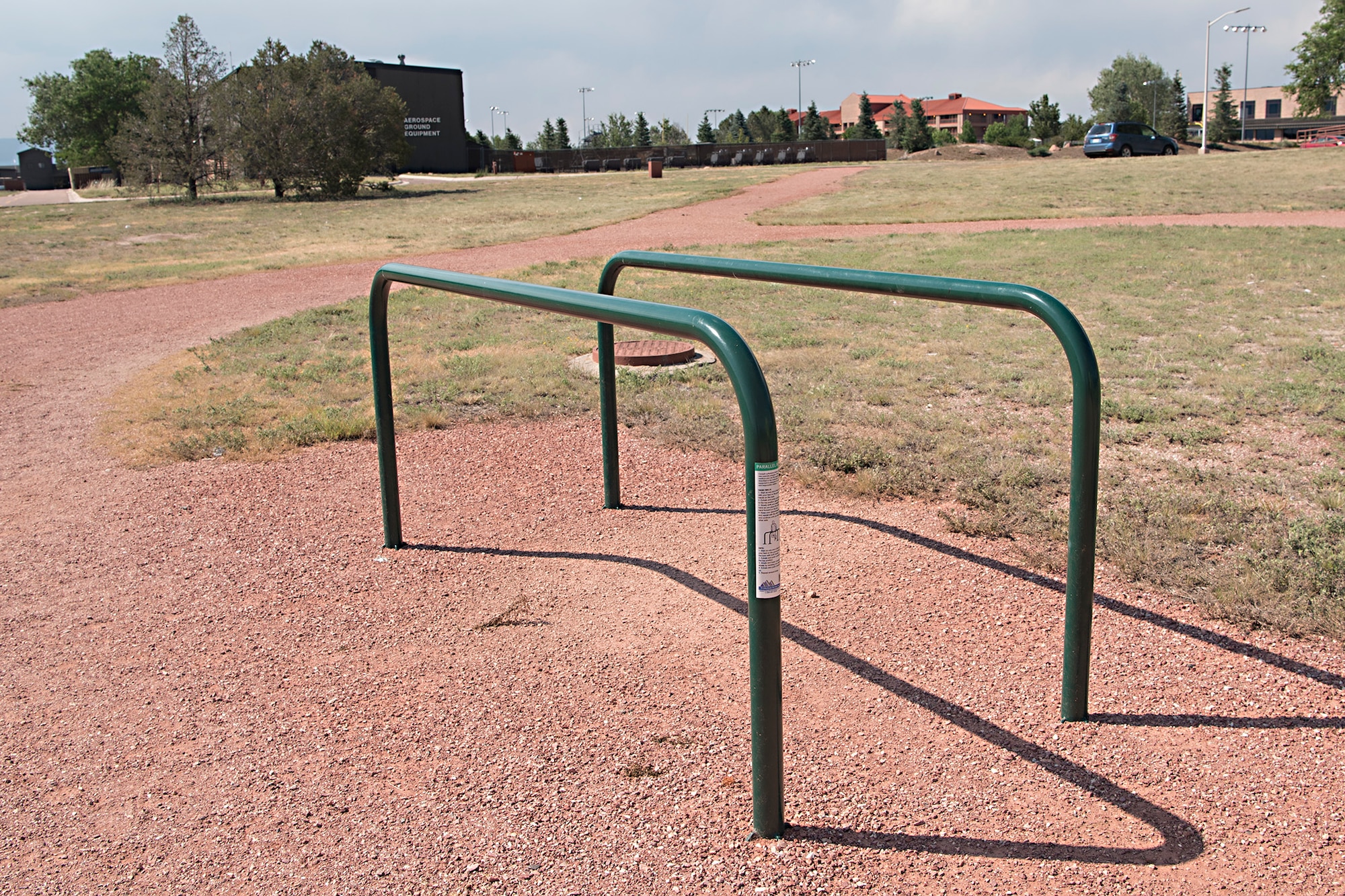 PETERSON AIR FORCE BASE, Colo. -- Parallel bars, on the Half Mile Loop Trail at Capt. David Lyon Memorial Park, Peterson Air Force Base, Colo., June 29, 2017, work shoulders and core while maneuvering across them. The trail offers over 10 exercise stations on a gravelled running path. (U.S. Air Force Photo by Steve Kotecki)