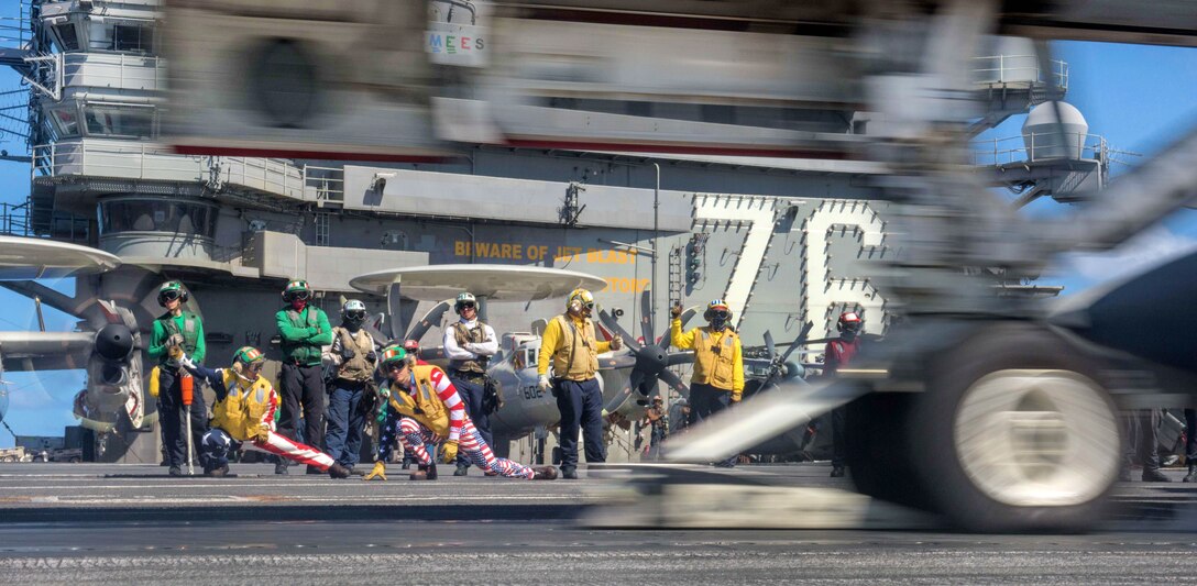 Navy Lts. Miranda Krasselt, left foreground, and Chris Williams signal for the launch of an aircraft on the flight deck aboard the aircraft carrier USS Ronald Reagan in the Pacific Ocean, July 4, 2017. Navy photo by Petty Officer 2nd Class Kenneth Abbate