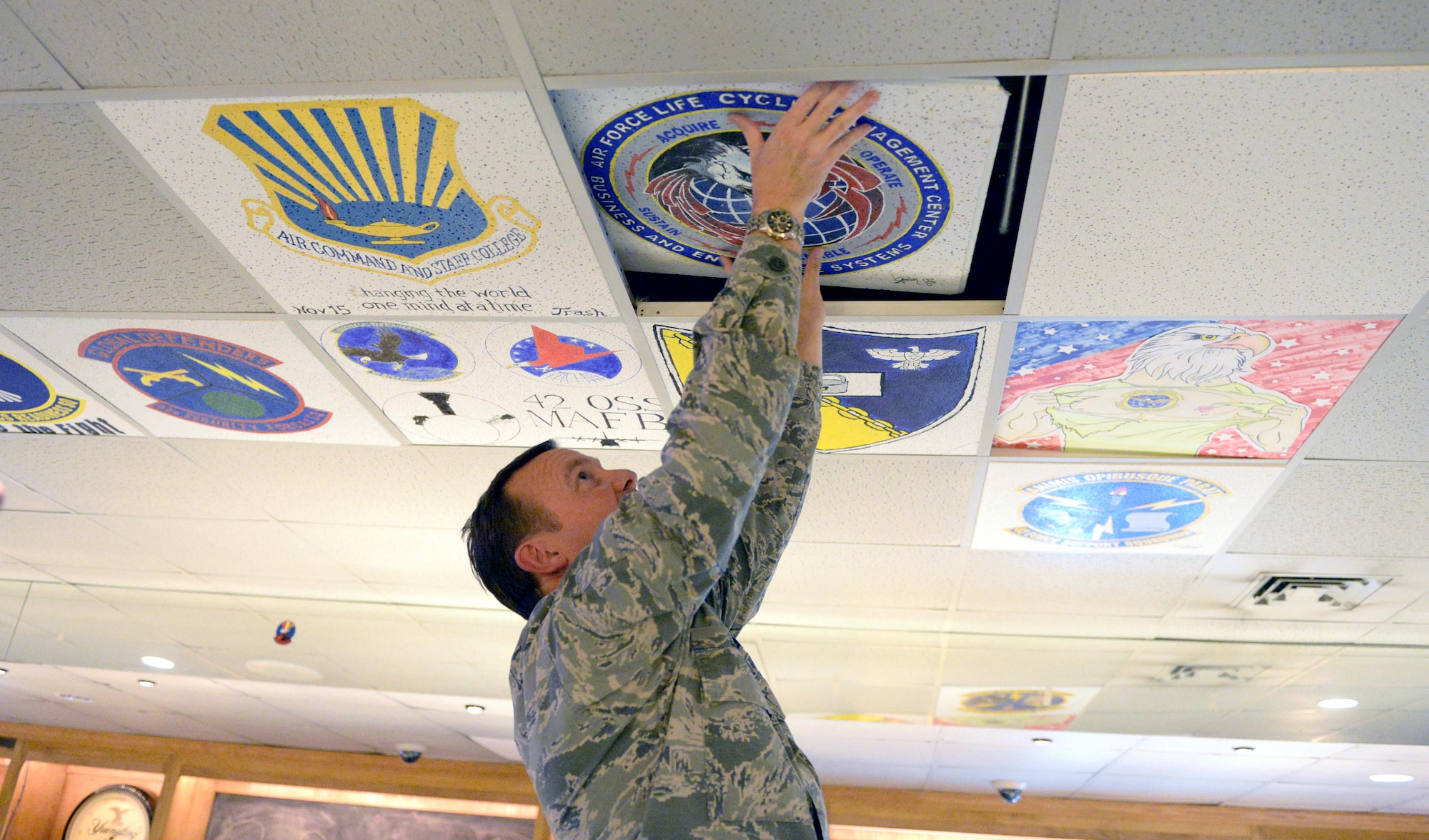 Col. Doanald Lewis, 42nd Mission Support Group commander, installs a ceiling tile in The Pit at the Maxwell Club, May 5, 2017. The Maxwell Club is changing its focus to create a comfortable environment for Airmen of all ranks to enjoy coming to The Pit. (U.S. Air Force photo/Senior Airman Tammie Ramsouer)