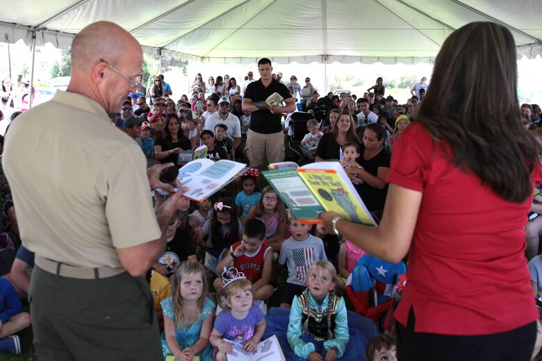Col. Gary S. Johnston, Chief of Staff, Marine Corps Installations - West, along with Alexa Garica, Disney Ambassador, and a volunteer from the crowd read aloud "The Big Guy Took My Ball" to children and their families during Books on Bases, Camp Pendleton, Calif., July 8th, 2017. Books on Bases brings books to military children and is a part of Blue Star Families' and The Walt Disney Company's  ongoing effort to to support military families across the nation. (U.S. Marine Corps Photo by LCpl. Dylan Chagnon)