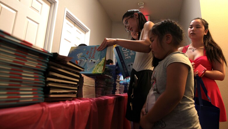 A mother helps her daughter choose a book during Books on Bases, Camp Pendleton, Calif., July 8th, 2017. Books on Bases brings books to military children and is a part of Blue Star Families' and The Walt Disney Company's  ongoing effort to to support military families across the nation. (U.S. Marine Corps Photo by LCpl. Dylan Chagnon)