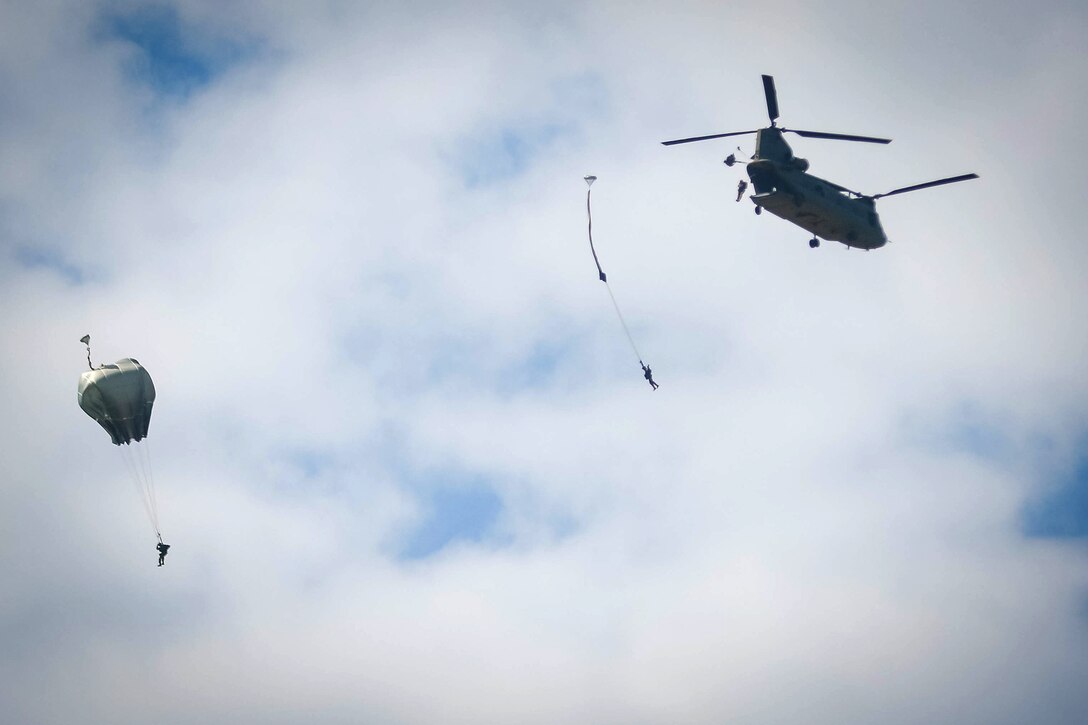 Paratroopers jump from a CH-47 Chinook helicopter during airborne operations over Sicily drop zone at Fort Bragg, N.C., July 6, 2017. The paratroopers are assigned to the 82nd Airborne Division’s 2nd Battalion, 505th Parachute Regiment, 3rd Brigade Combat Team. The helicopter crew is assigned to the 82nd Airborne Division’s 3rd General Support Aviation Battalion, 82nd Combat Aviation Brigade. Army photo by Sgt. Steven Galimore