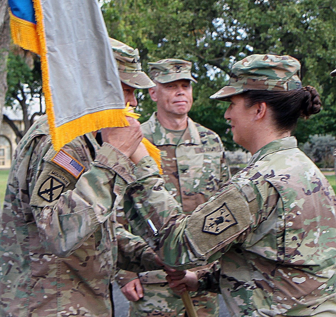 Col. Dustin Shultz (right) passes the colors of the 505th Military Intelligence Brigade (Theater) to Lt. Gen. Jeffery Buchanan (left), commanding general, U.S. Army North, during a change of command ceremony at Joint Base San Antonio-Fort Sam Houston July 7. Col. William Sears (center) took over as the brigade's commander.