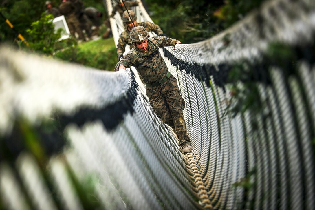 Marine Corps Cpl. Bryan Hernandezrodriguez and fellow Marines travel across a rope bridge during an endurance course at the Jungle Warfare Training Center at Camp Gonsalves in Okinawa, Japan, July 7, 2017. Hernandezrodriguez is a rifleman assigned to Bravo Company, 1st Battalion, 3rd Marine Regiment. Marine Corps photo by Cpl. Aaron S. Patterson