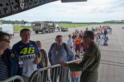 701st Airlift Squadron aircrew members chatted with spectators waiting in line to tour a C-17 Globemaster III at Royal Naval Air Station, U.K. who also have cool rides, and took this photo with them. Citizen Airmen from the 701st AS set the bar high by flying the first C-17 low-level pass through the “Mach Loop” and captured another win for their static display at the the air show Friday and Saturday. (U.S. Air Force Photo \ Tech. Sgt. Bobby Pilch)