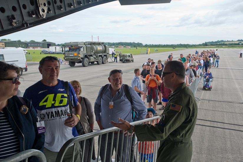 701st Airlift Squadron aircrew members chatted with spectators waiting in line to tour a C-17 Globemaster III at Royal Naval Air Station, U.K. who also have cool rides, and took this photo with them. Citizen Airmen from the 701st AS set the bar high by flying the first C-17 low-level pass through the “Mach Loop” and captured another win for their static display at the the air show Friday and Saturday. (U.S. Air Force Photo \ Tech. Sgt. Bobby Pilch)