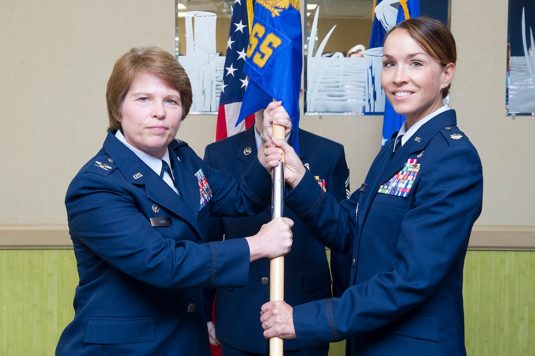 Col. Julie Stola, 45th Space Wing Medical Group commander, presents Lt. Col. Tara Lovell, 45th Medical Support Squadron commander, with the 45th MDSS guidon during a change of command ceremony July 10, 2017, at Patrick Air Force Base, Fla. Changes of command are a military tradition representing the transfer of responsibilities from the presiding officials to the upcoming official. (U.S. Air Force photo/Phil Sunkel) 