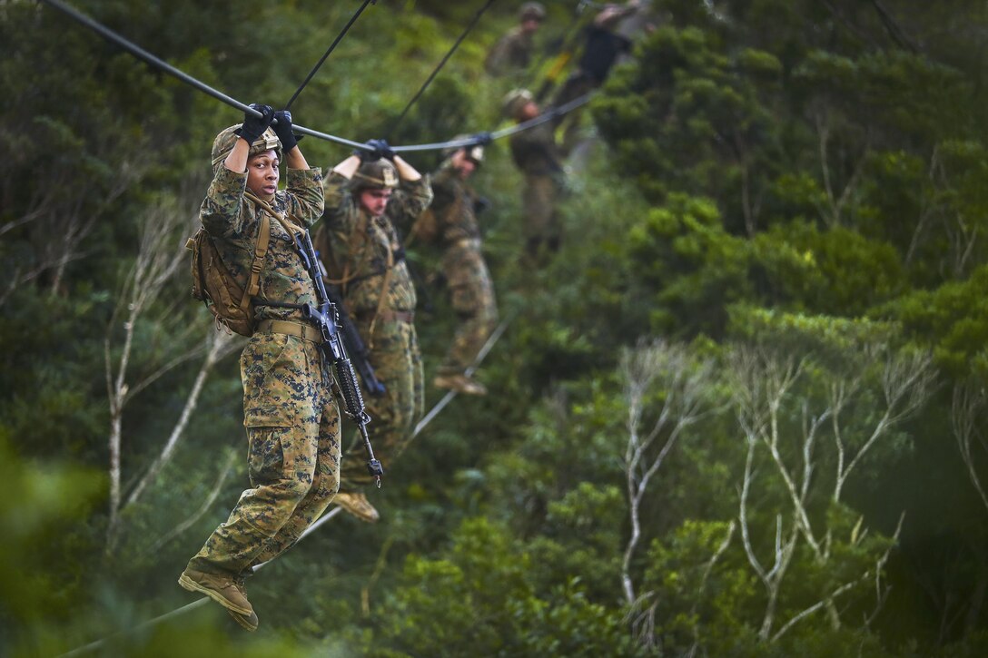 Marines move along a rope obstacle during an endurance course at the Jungle Warfare Training Center at Camp Gonsalves in Okinawa, Japan, July 7, 2017. The Marines are assigned to Bravo Company, 1st Battalion, 3rd Marine Regiment. Marine Corps photo by Cpl. Aaron S. Patterson