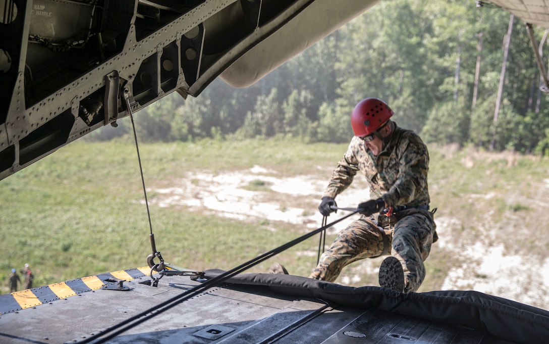 Staff Sgt. Jerry Colvin rappels out of a CH-53 Super Stallion during a ceremony at Stone Bay, a Camp Lejeune satellite training area, N.C., May 17, 2017.  The ceremony marks the reopening of Landing Zone Vulture, which closed Sept. 2, 2015 after a CH-53 crashed resulting in the death of one Marine.  The instructors took the opportunity to memorialize their fallen Marine, Staff Sgt. Jonathan Lewis, through the sustainment rappel. Colvin is with EOTG, II Marine Expeditionary Force Headquarters Group.