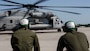 Two Marines observe the CH-53 Super Stallion as it prepares to take off for a ceremony at Marine Corps Air Station New River, N.C., May 17, 2017.  The ceremony marks the reopening of Landing Zone Vulture, which closed Sept. 2, 2015 after a CH-53 crashed resulting in the death of one Marine.  The instructors took the opportunity to memorialize their fallen Marine, Staff Sgt. Jonathan Lewis, through the sustainment rappel. The Marines are with EOTG, II Marine Expeditionary Force Headquarters Group.