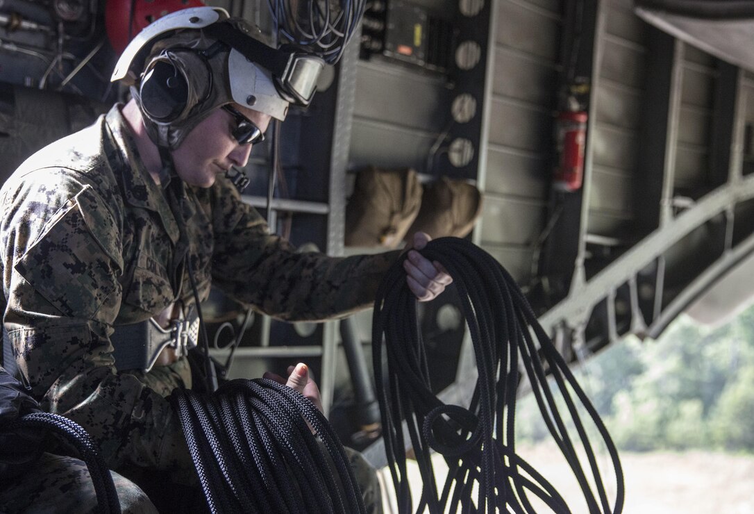 Staff Sgt. Jerry Colvin unravels a rope before rappelling out of a CH-53 Super Stallion during a ceremony at Stone Bay, a Camp Lejeune satellite training area, N.C., May 17, 2017.  The ceremony marks the reopening of Landing Zone Vulture, which closed Sept. 2, 2015 after a CH-53 crashed resulting in the death of one Marine.  The instructors took the opportunity to memorialize their fallen Marine, Staff Sgt. Jonathan Lewis, through the sustainment rappel. Staff Sgt. Colvin is with EOTG, II Marine Expeditionary Force Headquarters Group.