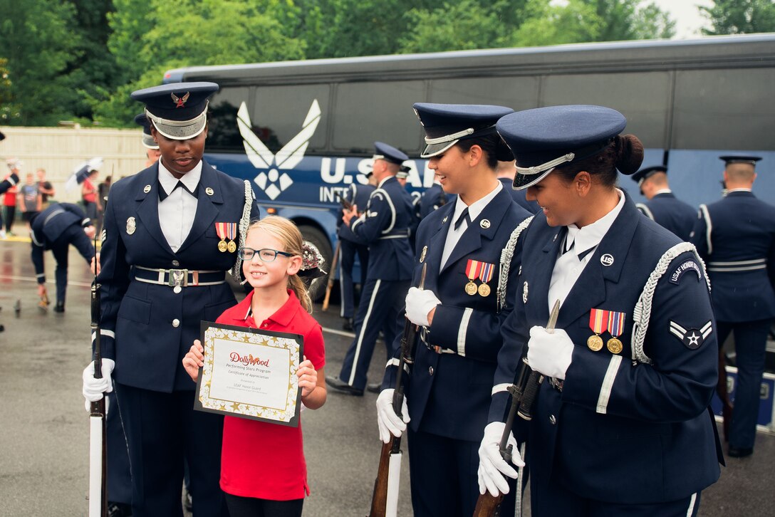 Members of the U.S. Air Force Honor Guard interact with an audience member after a flag raising ceremony at the Dollywood theme park in Pigeon Forge, Tenn., July 4, 2017. The ceremony provided an opportunity for the honor guard to honor veterans, inspire patriotism all while showcasing the Air Force mission. (U.S. Air Force photo by Senior Airman Delano Scott)