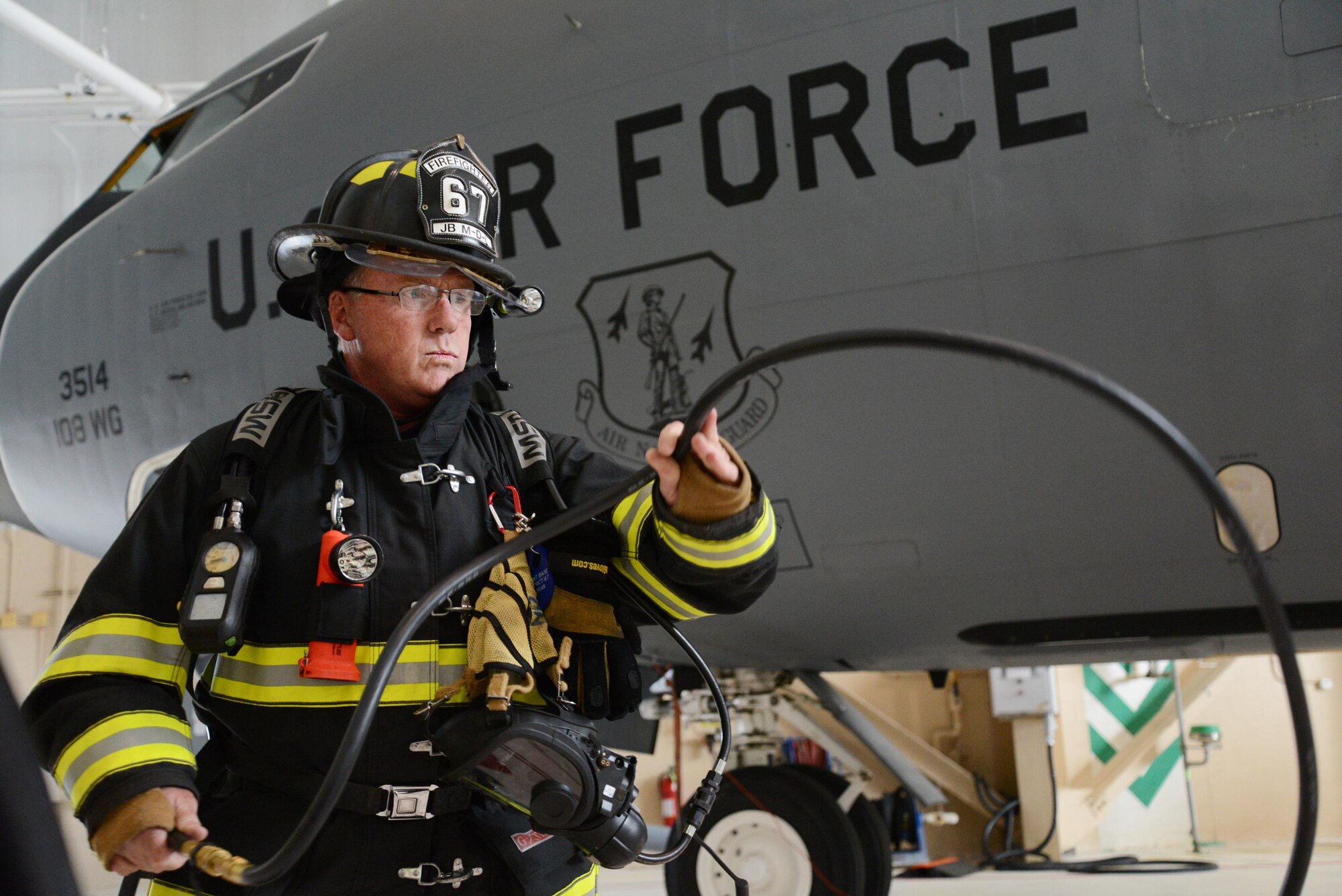 Kevin Horan, firefighter with the 87th Civil Engineering Squadron, 87th Air Base Wing, prepares equipment at the hangar where Airmen from the 108th Maintenance Squadron, 108th Wing, New Jersey Air National Guard, test the procedures to extract an unconscious victim from a KC-135R Stratotanker fuel tank at Joint Base McGuire-Dix-Lakehurst, N.J., Aug. 22, 2014. The exercise involved multiple Joint Base organizations including the 108th Wing and the 87th Bio-Environmental shops, the 87th Fire Department and both the 108th and the 87th Safety Offices. (U.S. Air National Guard Photo by Tech. Sgt. Carl Clegg/Released)