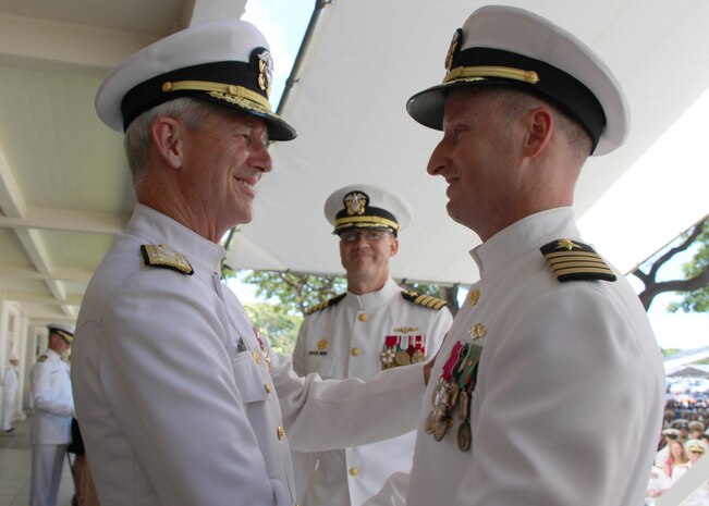 Vice Adm. Thomas Moore, Commander Naval Sea Systems Command, congratulates Capt. Jamie Kalowsky on Kalowsky's relief as commanding officer of Pearl Harbor Naval Shipyard and Intermediate Maintenance Facility.  The 47th and new commanding officer, Capt. Greg Burton looks on.  The change of command took place in front of the Shipyard Headquarters Building on Friday, July 7, 2017.  