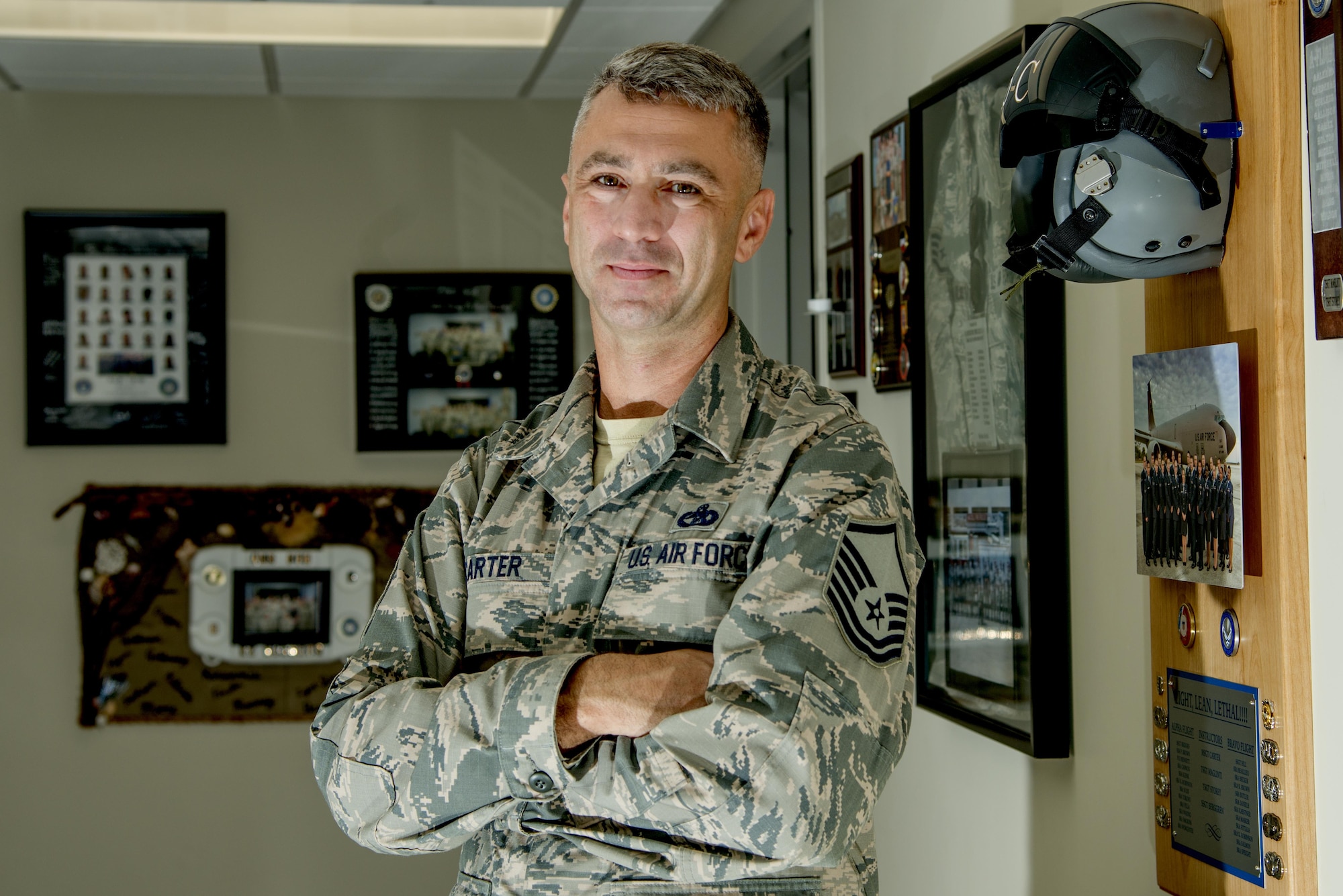 U.S. Air Force Master Sgt. Lonnie Carter, the commandant of the Chief Master Sgt. Aubert E. Dozier Airman Leadership School (ALS), pauses for a photo in front of legacy plaques at MacDill Air Force Base, Fla., July 7, 2017. Carter has served as the MacDill ALS Commandant for four years and is retiring after 20 years of service. (U.S. Air Force photo by Airman 1st Class Mariette Adams)