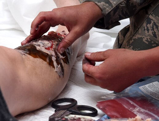 Tech. Sgt. Laura Pelkey, 341st Medical Operations Squadron NCO in charge of education and training, applies scar tissue injuries June 26, 2017, at Malmstrom Air Force Base, Mont. Pelkey uses moulage to recreate scenarios to provide the knowledge for military members to process different situations. (U.S. Air Force photo/Senior Airman Jaeda Tookes)