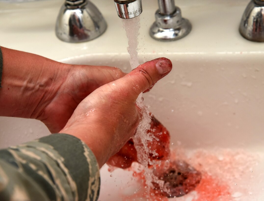 Tech. Sgt. Laura Pelkey, 341st Medical Operations Squadron NCO in charge of education and training, washes her hands after completing a moulage of a burn to the knee June 26, 2017, at Malmstrom Air Force Base, Mont. Moulage is the art of creating mock injuries for the purpose of training. (U.S. Air Force photo/Senior Airman Jaeda Tookes)