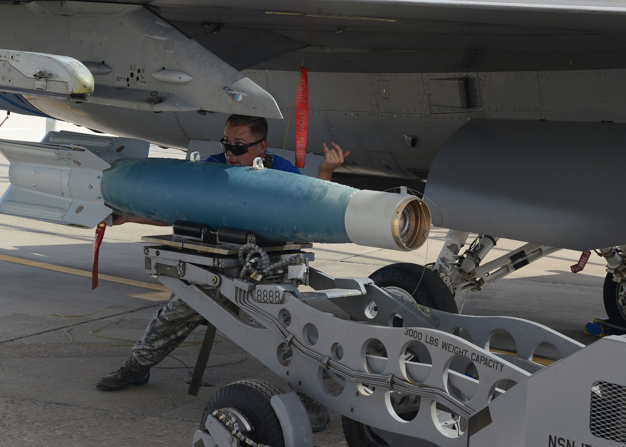 Staff Sgt. Jonathan Picher, 309th Aircraft Maintenance Unit load crew chief, guides an aerial stores lift truck while loading a GBU-12 Paveway II during the quarterly load crew competition at Luke Air Force Base, Ariz., July 7, 2017. The goal of the competition was to load two GBU-12s in under 30 minutes. (U.S. Air Force photo by Senior Airman James Hensley)