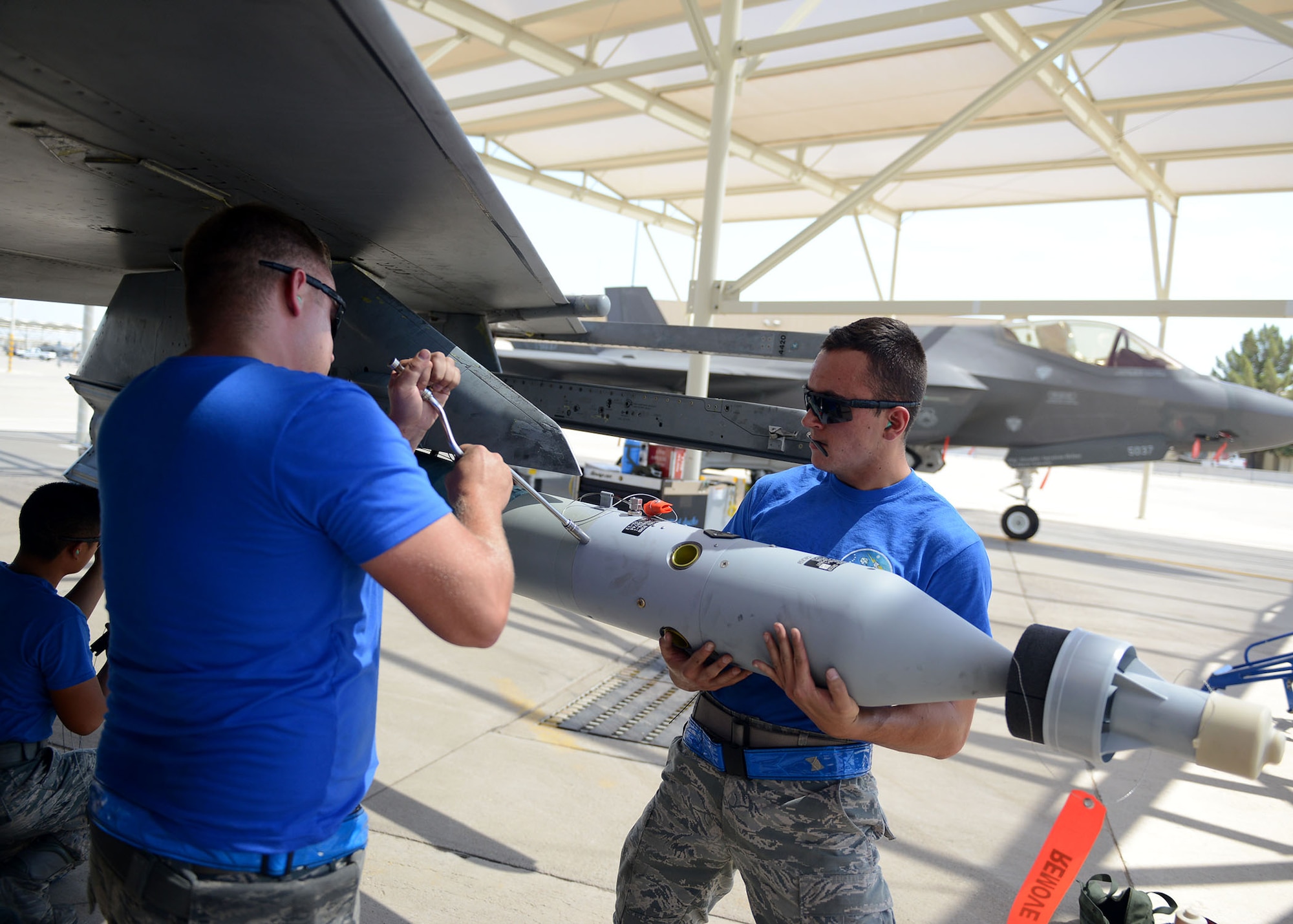 Airman 1st Class Antonio Rosario, 309th Aircraft Maintenance Unit load crew member, holds a GBU-12 Paveway II while Staff Sgt. Jonathan Picher, 309th AMU load crew chief, secures it during the quarterly load crew competition at Luke Air Force Base, Ariz., July 7, 2017. The goal of the competition was to load two GBU-12s in under 30 minutes. (U.S. Air Force photo by Senior Airman James Hensley)
