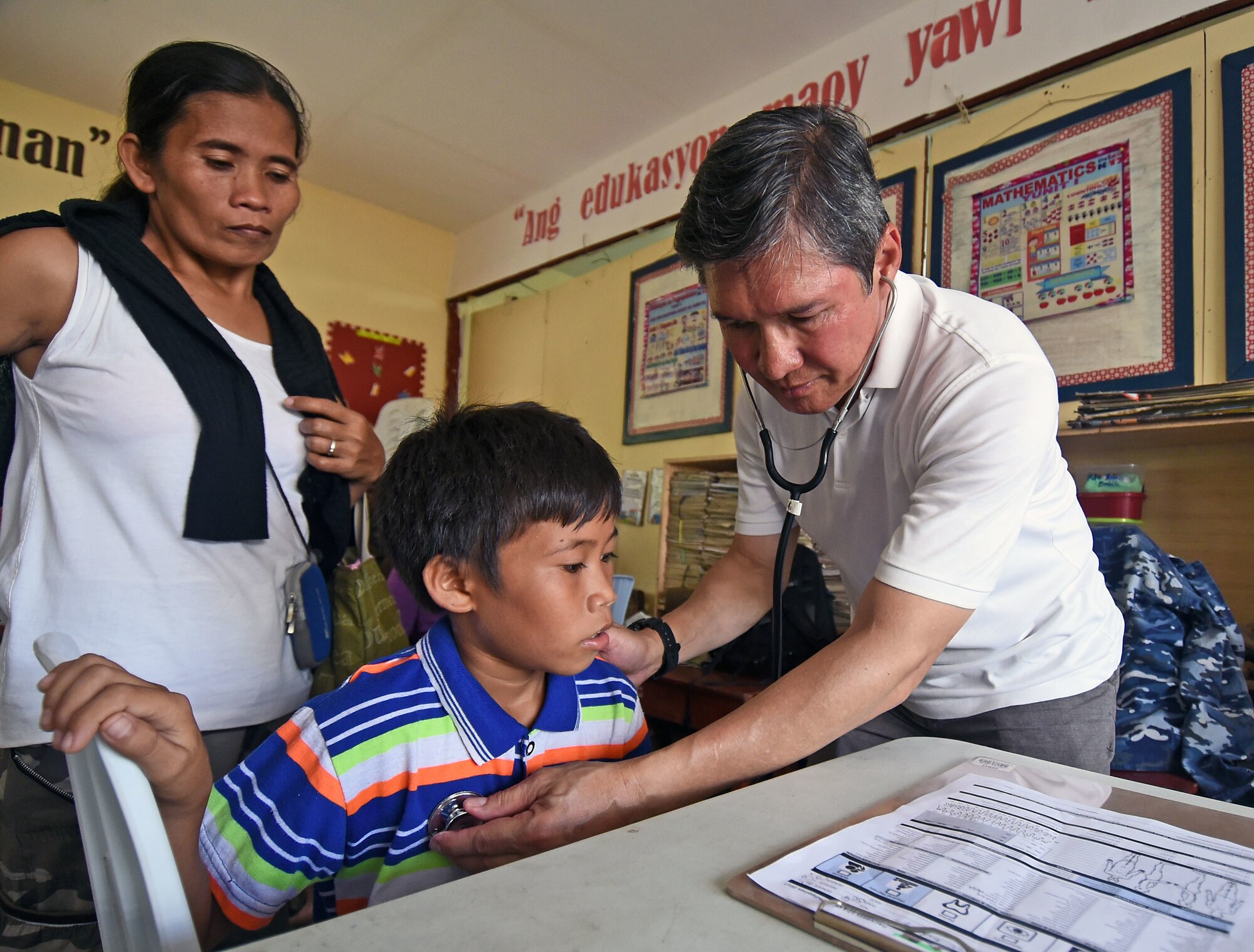 Dr. John Cinco, founder of Pacific Angel (PACANGEL), checks the vitals of a child from San Remigio during PACANGEL 2017 in Northern Cebu Province, Philippines, June 29, 2017. PACANGEL is a multilateral humanitarian assistance civil military engagement, which improves military-to-military partnerships in the Pacific while also providing medical health outreach, civic engineering projects and subject matter exchanges among partner forces. (U.S. Air Force photo/Master Sgt. Jeff Andrejcik)