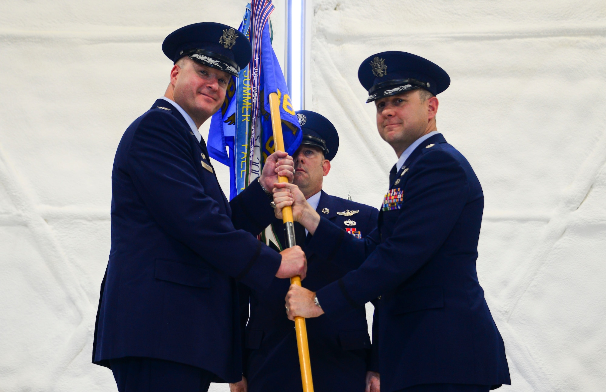 Col. Richard Carrel, 59th Operations Group commander, passes the 36th Rescue Squadron guidon to Lt. Col. Chad Kohout, 36th RQS commander, during a change of command ceremony July 7, 2017, at Fairchild Air Force Base, Washington. Kohout assumed command from Lt. Col. Jason Snyder. (U.S. Air Force photo/Senior Airman Janelle Patiño)